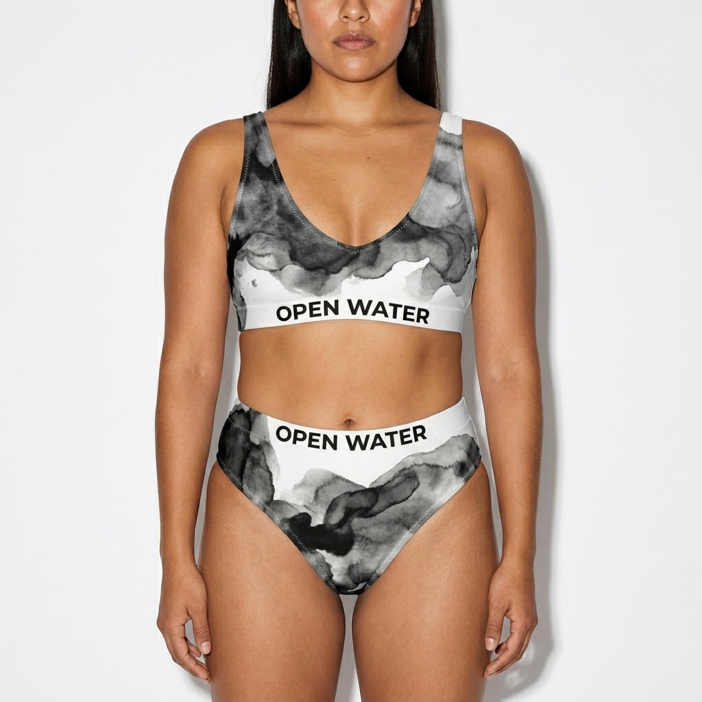All-Over Print Recycled High-Waisted Bikini worn by a broad-shouldered Mexican female fashion influencer, gorpcore outdoor styling, studio lookbook — custom all-over print recycled high-waisted bikini
