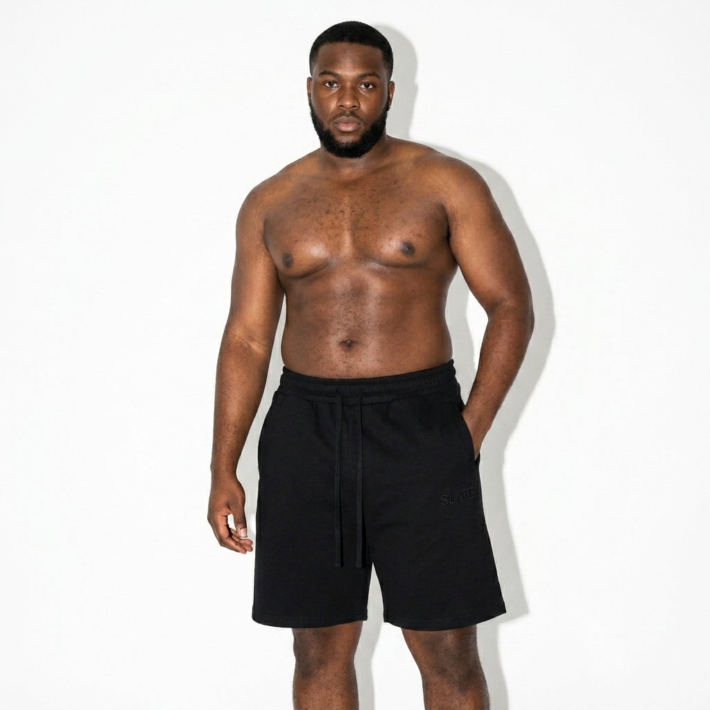 Essential Cotton Shorts worn by a curvy Afro-Caribbean male fashion influencer, clean-girl minimal styling, studio lookbook — custom essential cotton shorts
