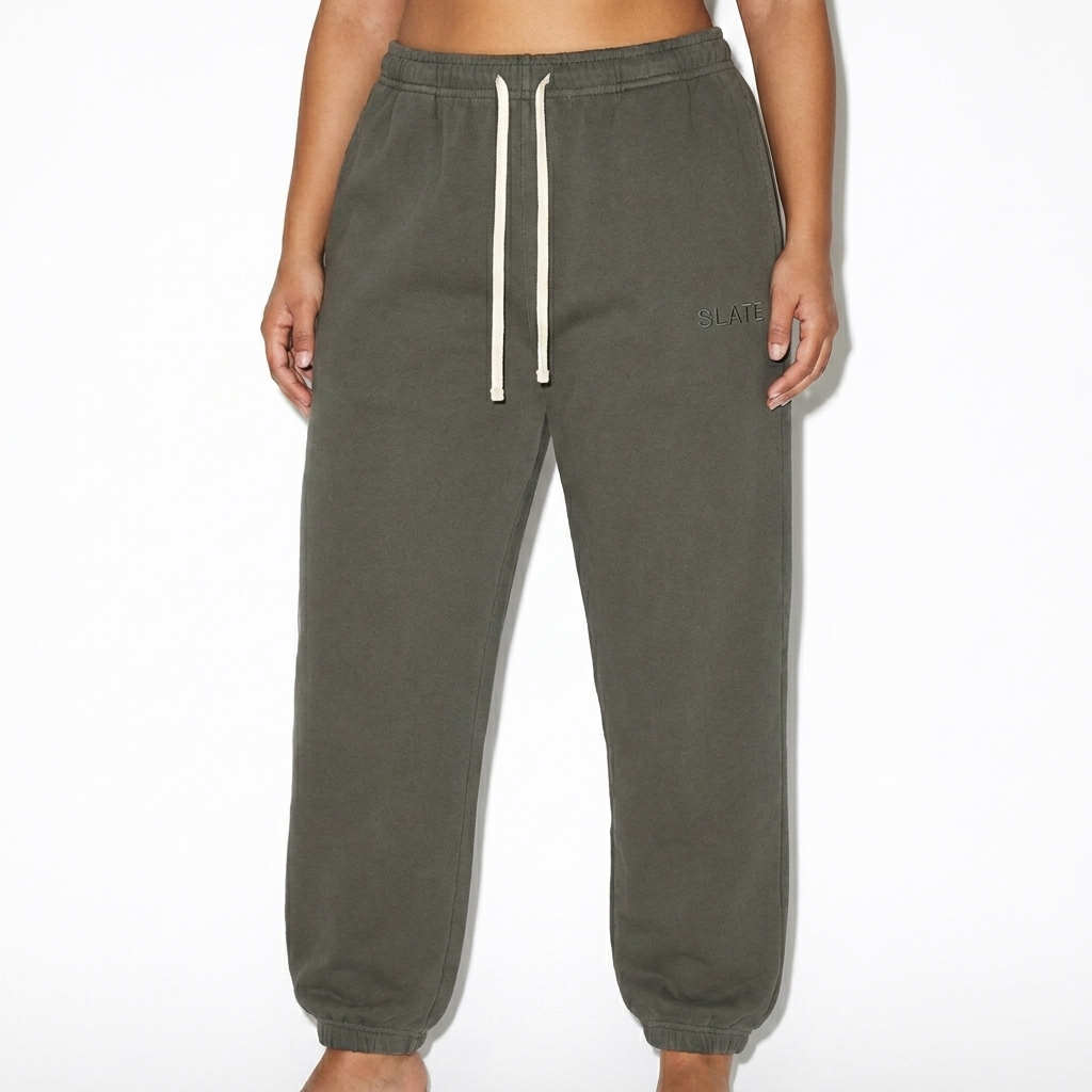 Garment-Dyed Fleece Sweatpants worn by a broad-shouldered Middle Eastern female fashion influencer, techwear modern styling, studio lookbook — custom garment-dyed fleece sweatpants