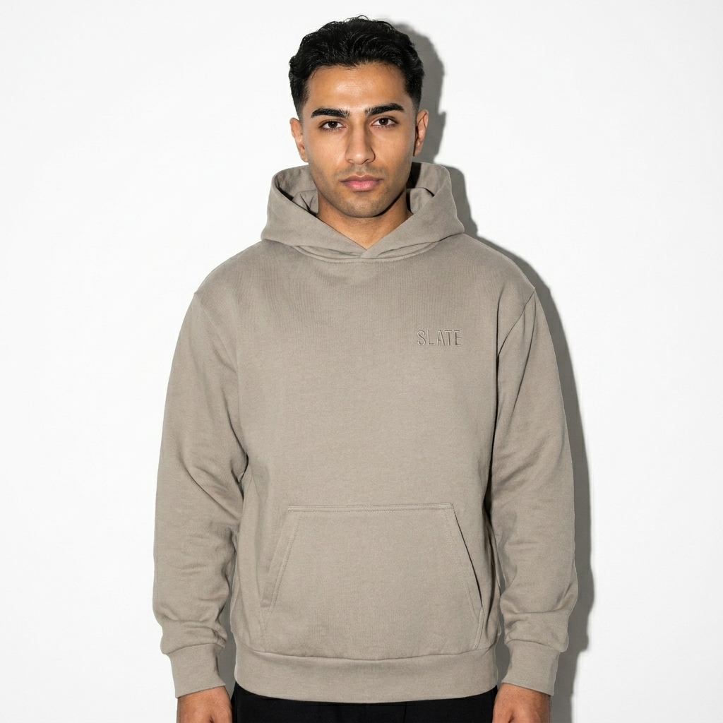 Heavyweight Garment-Dyed Hoodie worn by a petite Persian male fashion influencer, gorpcore outdoor styling, studio lookbook — custom heavyweight garment-dyed hoodie