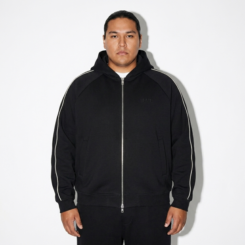 Heavyweight Raglan Zip Hoodie worn by a curvy Indigenous American male fashion influencer, minimalist luxury styling, studio lookbook — custom heavyweight raglan zip hoodie