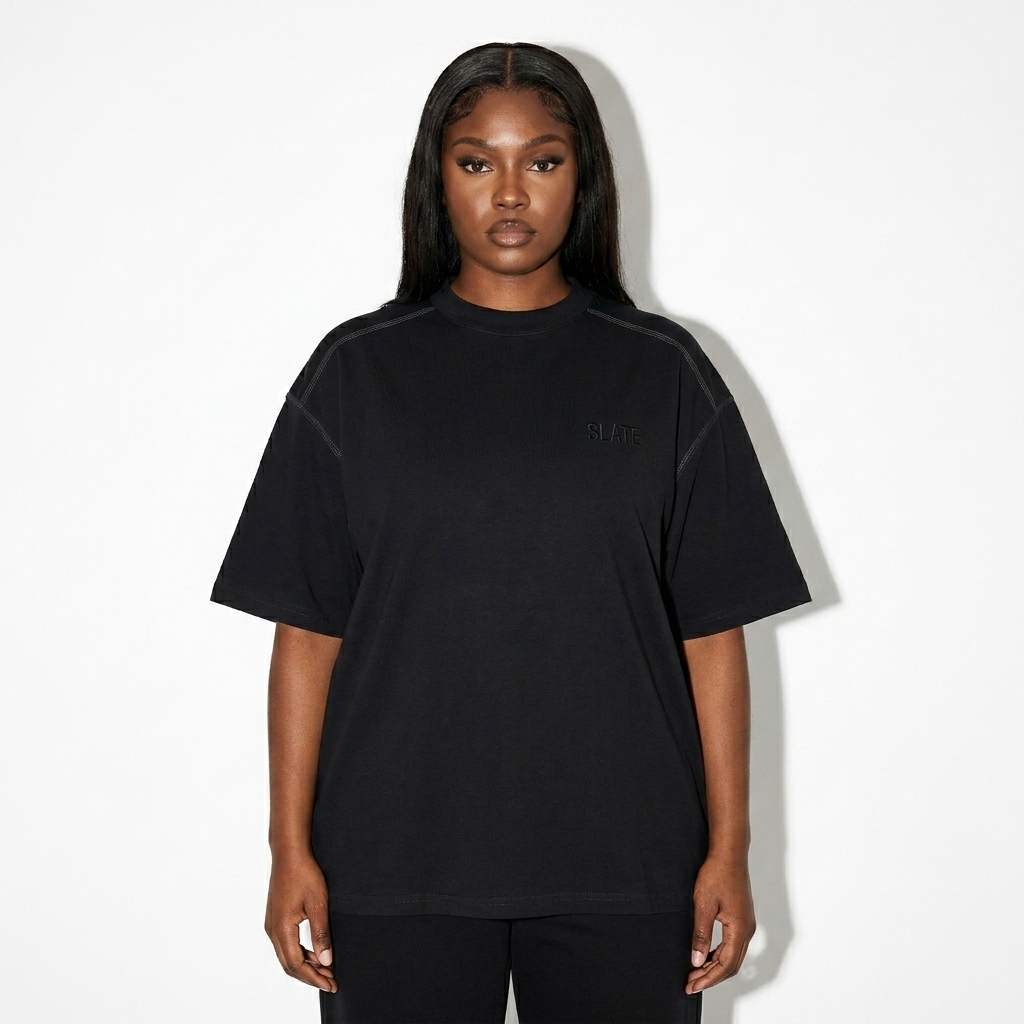 Oversized Contrast-Stitched Cotton Tee worn by a mid-size Black female fashion influencer, minimalist luxury styling, studio lookbook — custom oversized contrast-stitched cotton tee