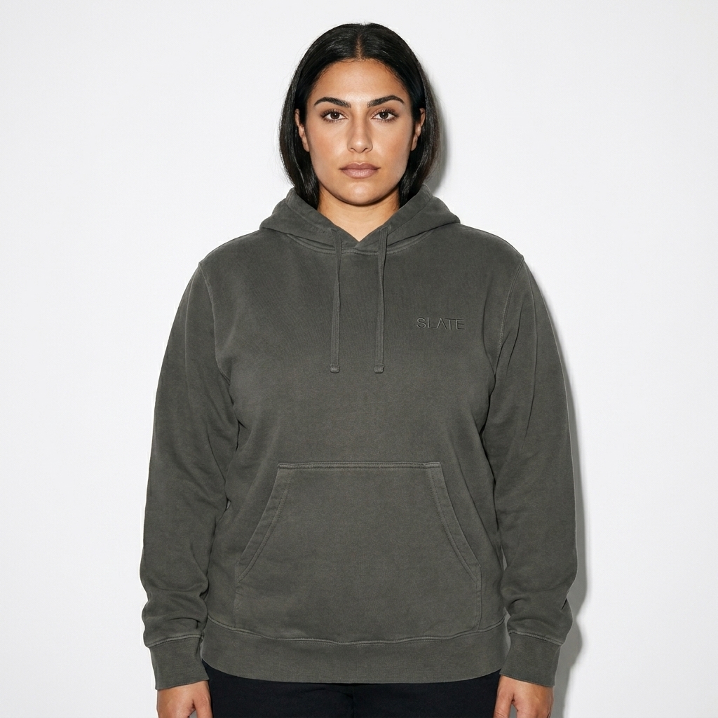 Pigment-Dyed Pullover Hoodie worn by a broad-shouldered Mediterranean female fashion influencer, minimalist luxury styling, studio lookbook — custom pigment-dyed pullover hoodie