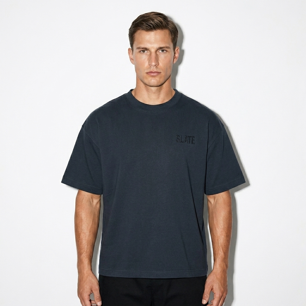 Unisex Boxy Drop Shoulder T-Shirt worn by a toned German male fashion influencer, downtown streetwear styling, studio lookbook — custom unisex boxy drop shoulder t-shirt