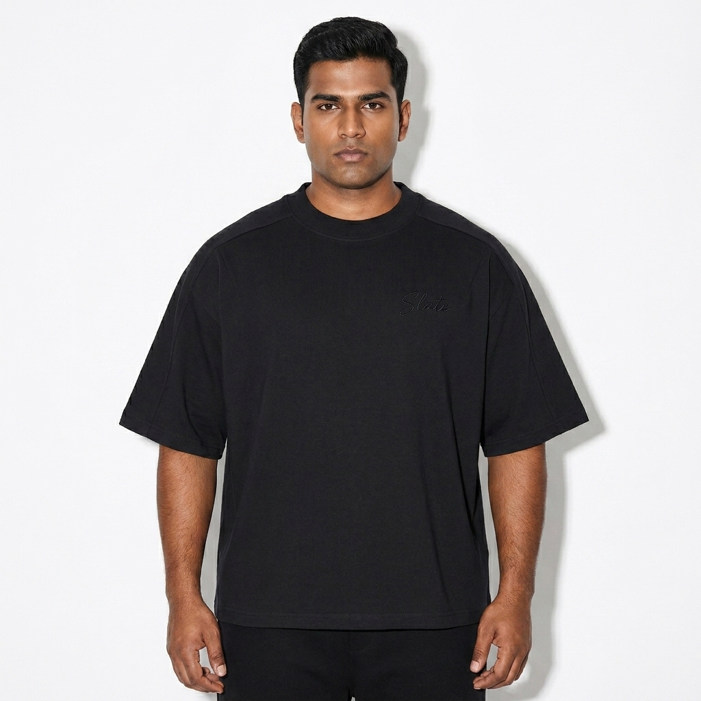 Unisex Boxy Tonal T-Shirt worn by a broad-shouldered Indian male fashion influencer, minimalist luxury styling, studio lookbook — custom unisex boxy tonal t-shirt