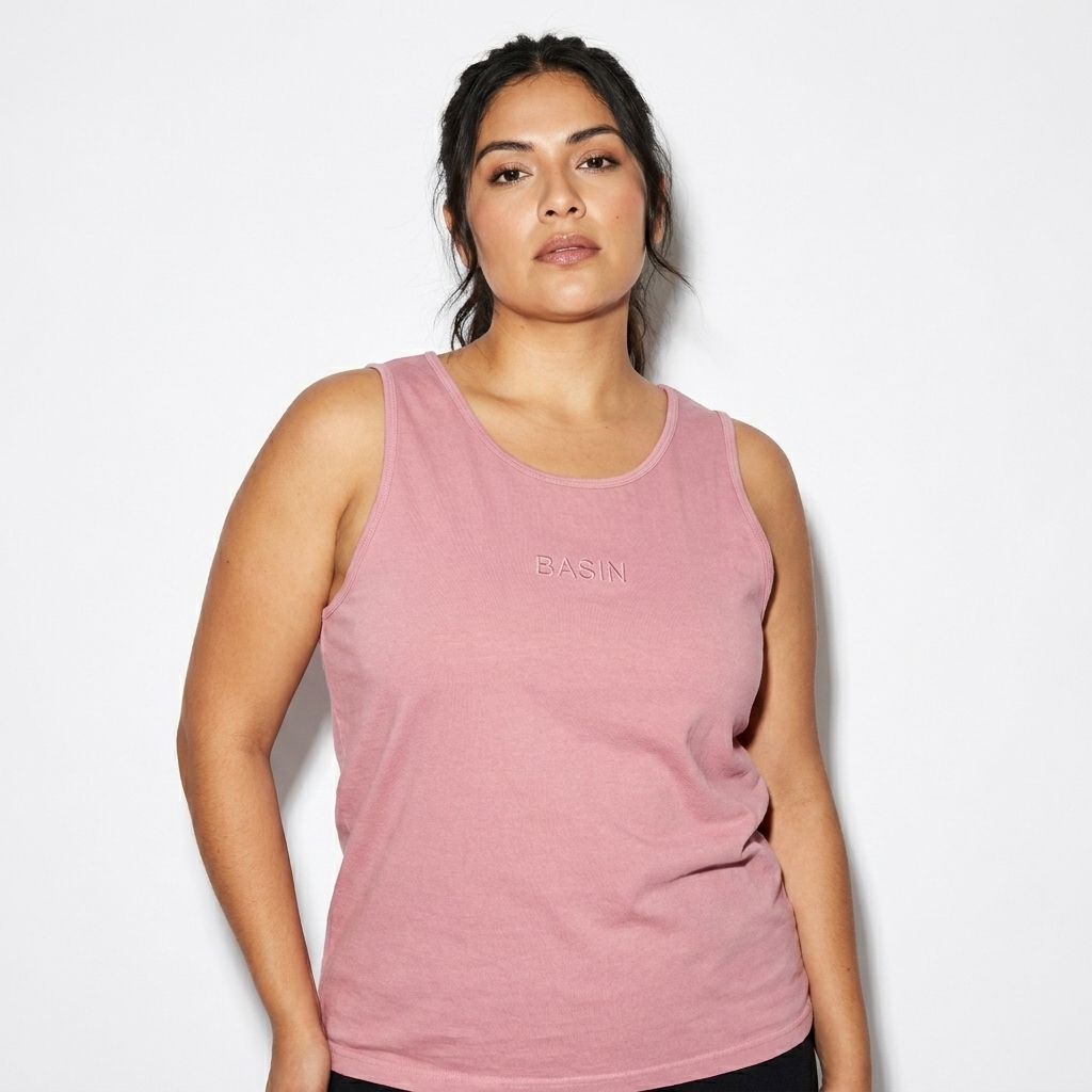 Unisex Garment-Dyed Tank Top worn by a mid-size Mexican female fashion influencer, minimalist luxury styling, studio lookbook — custom unisex garment-dyed tank top