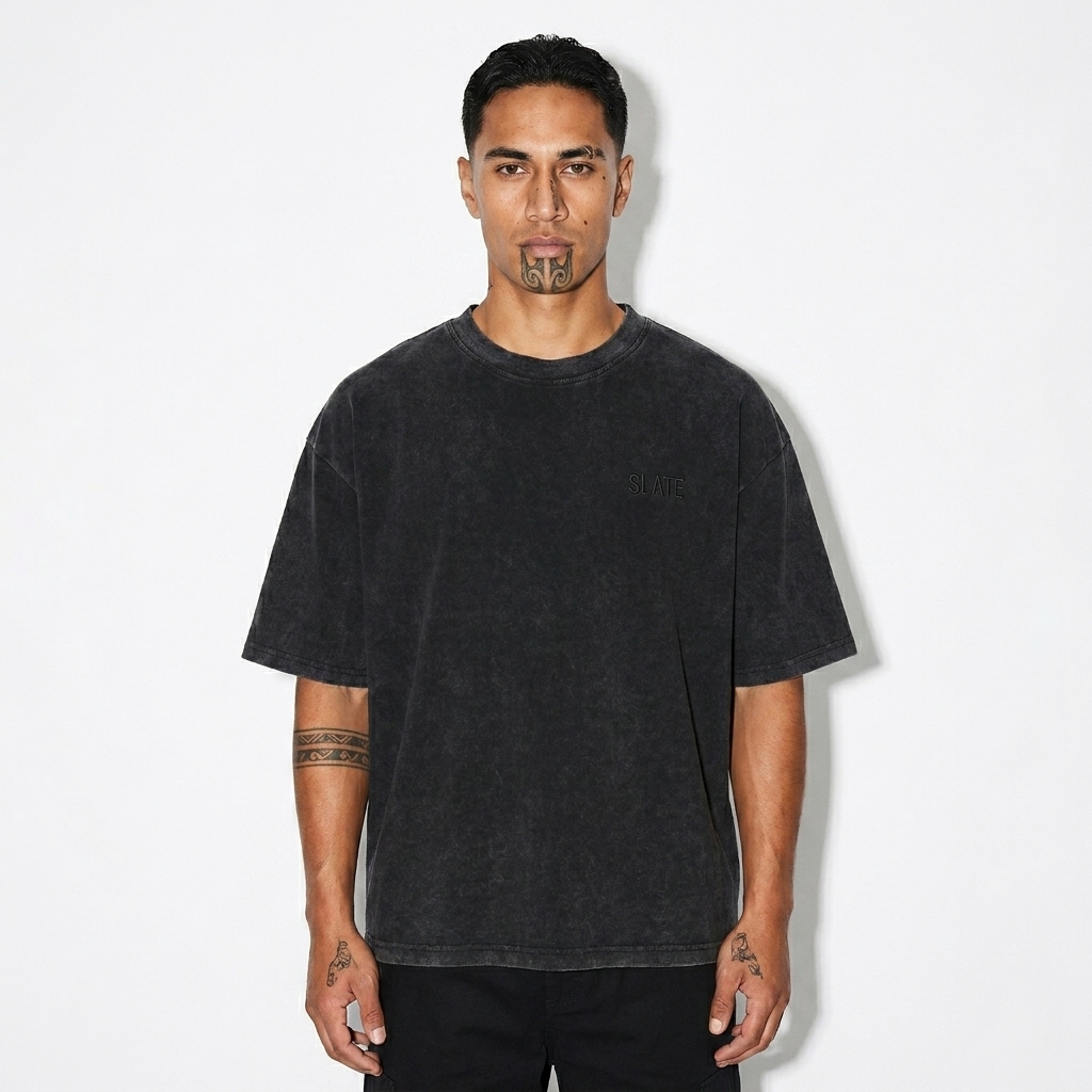 Unisex Mineral Wash Boxy T-Shirt worn by a lean Māori male fashion influencer, clean-girl minimal styling, studio lookbook — custom unisex mineral wash boxy t-shirt
