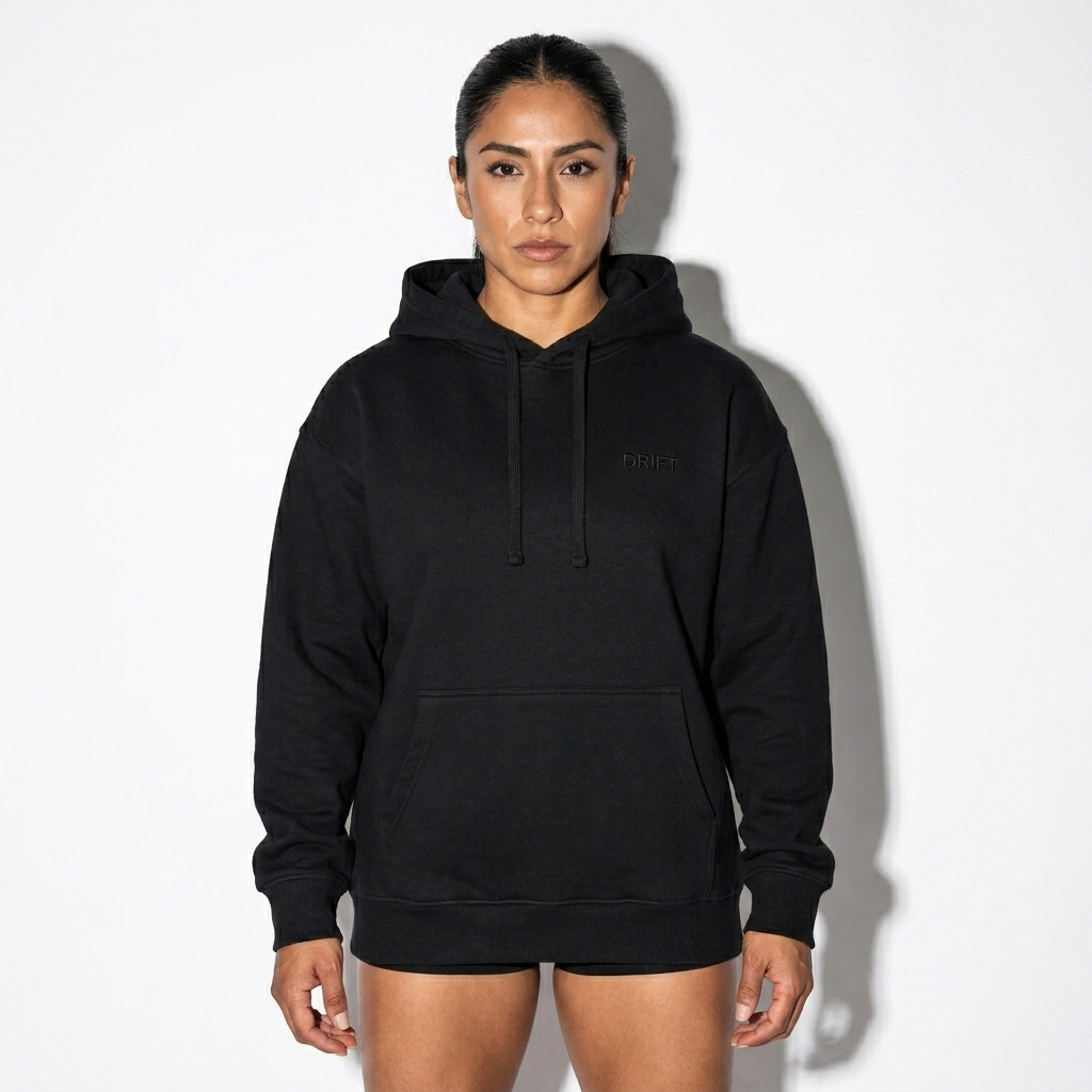 Unisex Organic Relaxed Hoodie worn by a athletic muscular Mexican female fashion influencer, techwear modern styling, studio lookbook — custom unisex organic relaxed hoodie