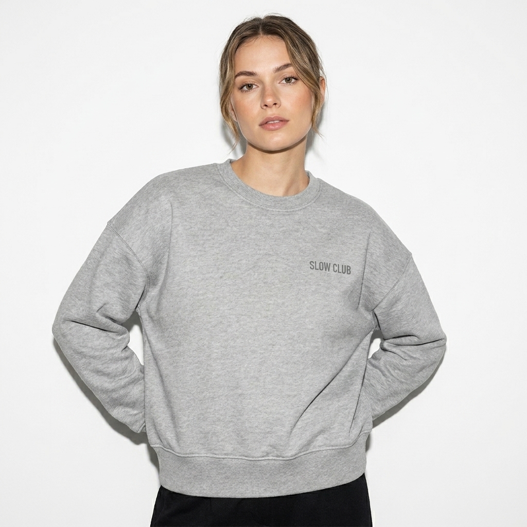 Women's Organic Crewneck Sweatshirt worn by a petite German female fashion influencer, gorpcore outdoor styling, studio lookbook — custom women's organic crewneck sweatshirt