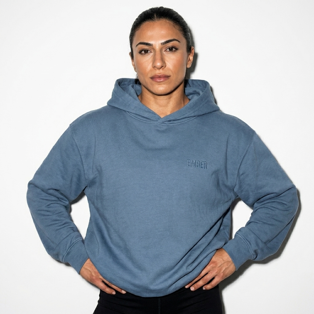 Youth Garment-Dyed Hooded Sweatshirt worn by a athletic muscular Turkish female fashion influencer, sporty athleisure styling, studio lookbook — custom youth garment-dyed hooded sweatshirt